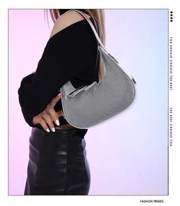 Detail view of the silver rhinestone crescent shoulder bag with shiny moon-shaped finish