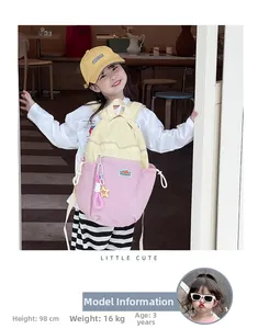 Toddler girl wearing pink and yellow contrast schoolbag with star pendant detail