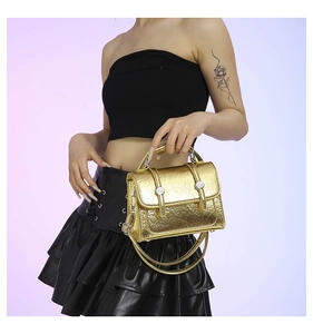Close-up of metallic pleated texture and silver buckles on a mini crossbody handbag