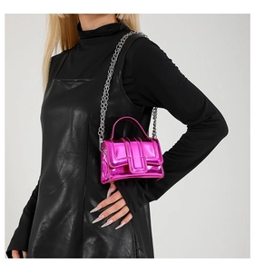 Mini sac en cuir verni rose fuchsia avec chaîne argentée sur une tenue noire