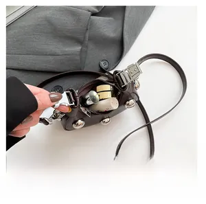 Mini brown rivet crossbody bag interior showing storage space for cosmetics