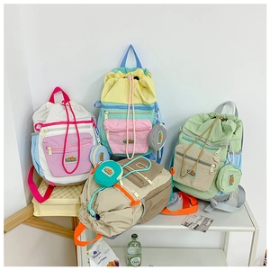 Detailed view of color-block drawstring backpacks with matching small pouches and pockets