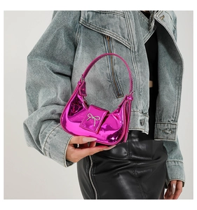 Detail of glossy pink crescent handbag with silver bow metal buckle and mirror finish