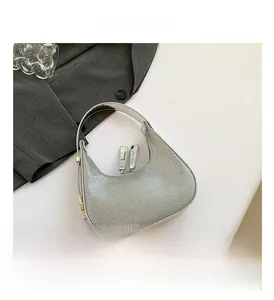 Detail of silver rhinestone crescent hobo bag with sleek metal zippers and top handle