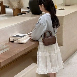 Brown leather mini bowling bag for toddlers with letter embossing and golden metal hardware