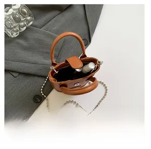 Detail der karamellbraunen Mini-Beuteltasche zeigt Innenraum für Make-up-Artikel