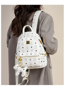 Vue détaillée du sac à dos blanc avec motifs d'ours et un pendentif mignon en forme de chien