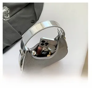 Interior view showing the capacity of a silver crescent moon bag for phone and cosmetics