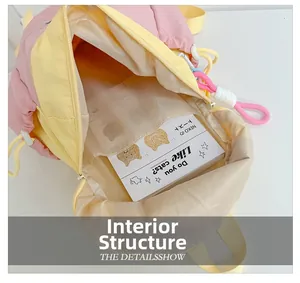 Detail of pink and yellow backpack interior showing mesh compartment with a book