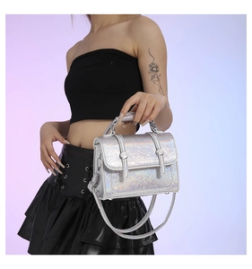 Close-up of silver laser-treated messenger bag with glossy crinkle texture and buckles