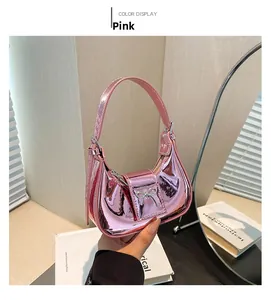 Detail of pink glossy mini hobo bag featuring a metal bow accent and smooth mirror finish
