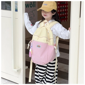 Outdoor shot of a pink and beige color-block kids backpack with adjustable straps