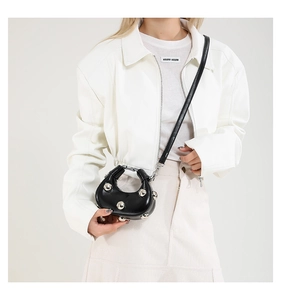 Detail view of black moon-shaped hobo bag with silver rivet studs and fine strap