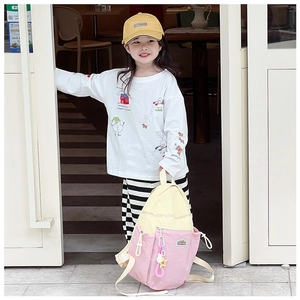 Detail of pink and yellow color-block school backpack with decorative side clip on child