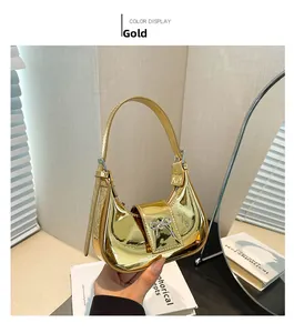 Close-up of golden hobo handbag featuring a metallic mirror finish and silver bow detail