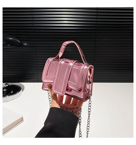 Détail du mini sac en cuir verni rose métallisé avec chaîne argentée et poignée courte