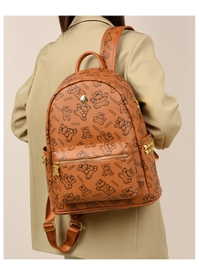 Vue détaillée de dos d'une femme portant un sac à dos marron imprimé ours en décor épuré