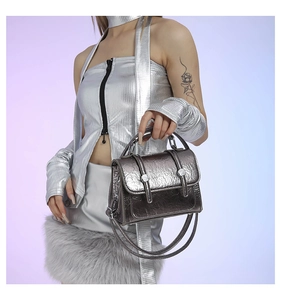 Detail of silver metallic handbag with cracked texture and rivet strap decorations