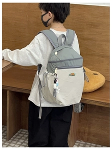 Detail of multi-pocket contrast color school bag with mountain logo on adjustable straps