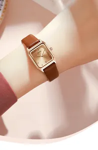 Close-up of elegant square GEDI quartz watch with rose gold case and brown leather strap