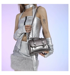 Detail of silver metallic postman bag with cracked texture and dual cylindrical buckles