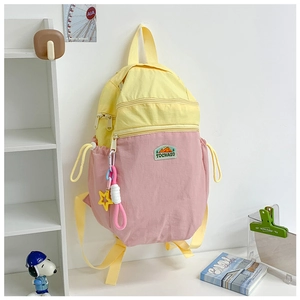 Detail of color-block kids backpack with star charm and side drawstring pocket
