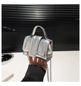 Détails du mini sac à main argenté avec bandoulière chaîne et finition miroir