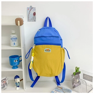 Detail of color-block backpack with durable nylon fabric and woven key charm