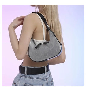 Close-up of sparkling silver rhinestone hobo bag with black leather straps and dual zippers