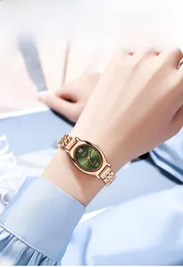 Detail van roségoud stalen horloge met groene wijzerplaat en vijf-schakels armband