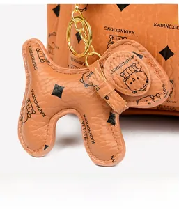Details des Vintage-Rucksacks in Karamell mit Bärenprint und Hunde-Lederanhänger