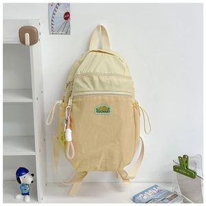 Detail of cream school backpack with mountain logo patch and star charm accessory