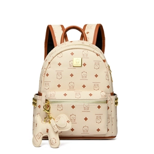 Détail du sac à dos crème avec imprimés d'ours et pendentif en forme de chien mignon