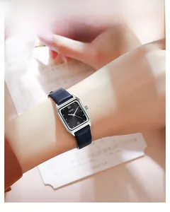 Close-up of GEDI rectangular silver watch with black leather strap worn by a model