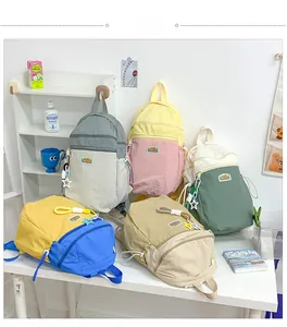 Detailed display of color-block backpacks in grey, pink, green, yellow, and khaki with stars