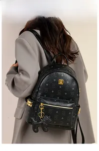 Detail eines schwarzen Vintage-Rucksacks mit Goldnieten und Hund-Anhänger