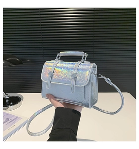 Detail of mini laser holographic handbag with textured iridescent finish and buckles