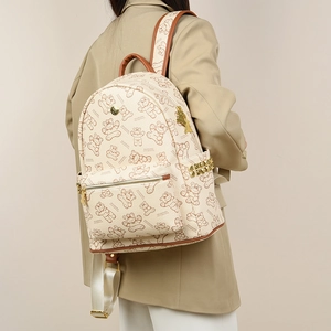 Détail du sac à dos imprimé beige montrant les clous dorés et les motifs d'ours
