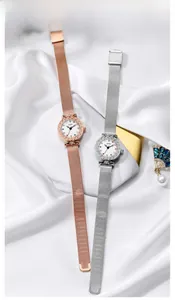 Close-up of luxury women's watch with colored gemstone scales and engraved bezel details