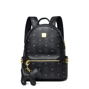 Détails du sac à dos noir avec rivets dorés et un joli charme de chien en cuir
