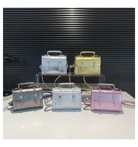Detailed view of five mini metallic crossbody bags with pleated texture and double buckles