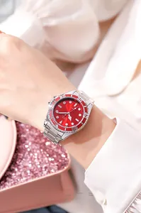 Close-up of elegant women's watch with red dial and silver stainless steel strap on wrist