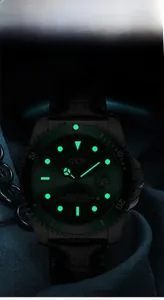 Nahaufnahme der GEDI-Uhr mit grünem Leuchtzifferblatt und Kalenderlupe auf dunklem Grund