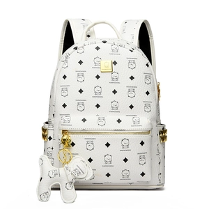 Détail d'un sac à dos en cuir blanc avec imprimé ours et plaque logo dorée brillante