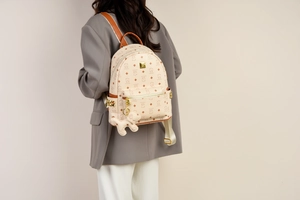 Detailansicht beige Rucksack mit Bärenmuster, Goldnieten und süßem Plüsch-Anhänger