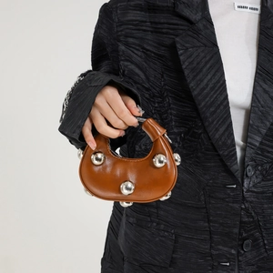 Fashionable brown leather moon bag with oversized silver studs and a semi-circular handle