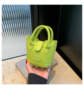 Detail der neongrünen Mini-Beuteltasche mit Lychee-Narbung und silberner Kette