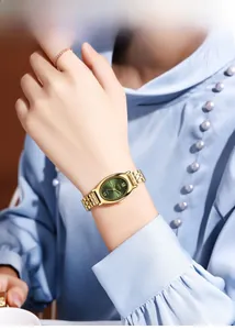 Detailopname van gouden ovaal horloge met groene zonnestraal wijzerplaat