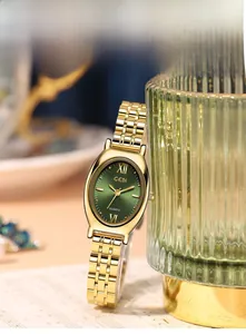 Detail van vintage ovaal goud horloge met groene wijzerplaat op groen getextureerd glas
