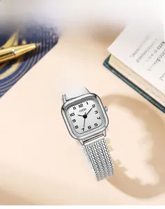 Close-up of vintage square quartz watch with silver wheat-ear mesh strap on desk
